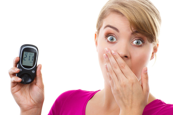 Shocked woman holding glucometer, measuring and checking sugar level, concept of diabetes - Photo, Image