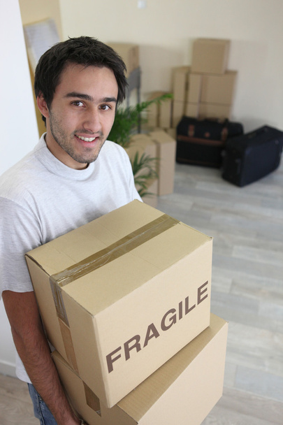 Young man moving boxes marked f - Photo, Image