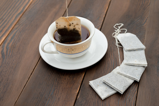 taza de té y nuevas bolsas de té sobre un fondo de madera
 - Foto, imagen