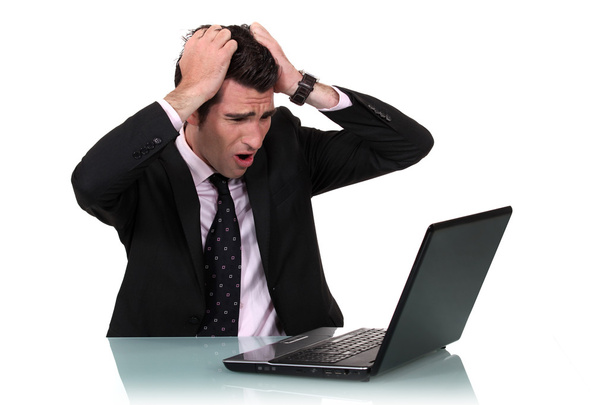 A businessman pissed at his laptop. - 写真・画像