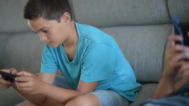 Boy relaxing with phone in living room - Filmagem, Vídeo
