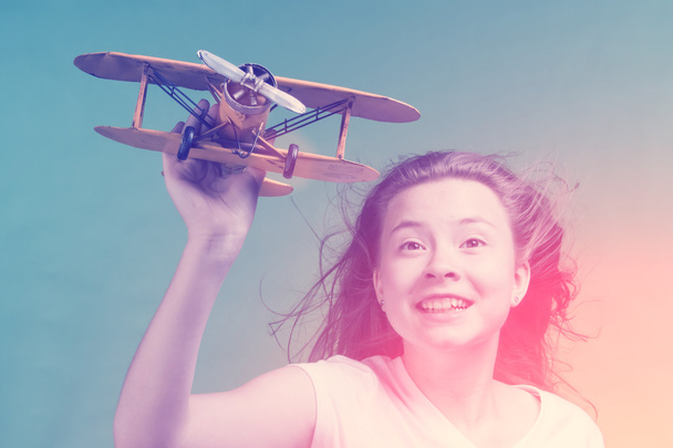 Leuk meisje spelen met vliegtuig model - Foto, afbeelding