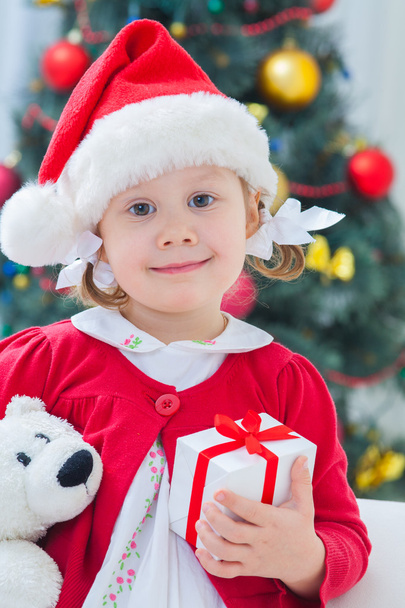 girl in Christmas hat holding presents - Photo, Image