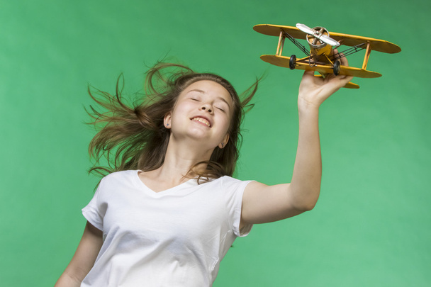 Cute girl playing with airplane model - Fotó, kép