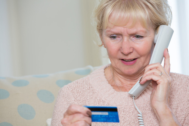 Seniorin gibt am Telefon Kreditkartendaten an - Foto, Bild