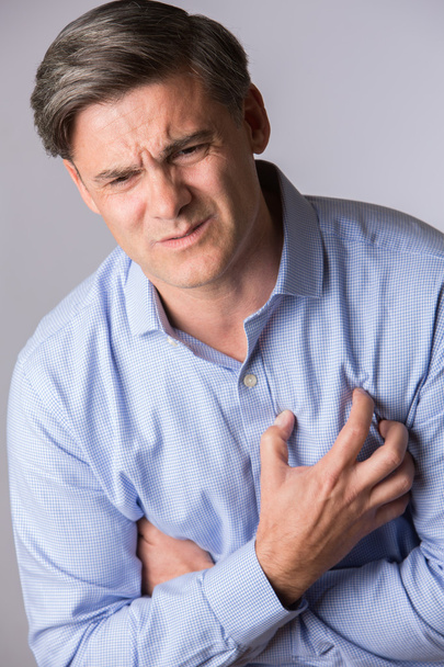 Estúdio tiro de homem maduro sofrendo ataque cardíaco
 - Foto, Imagem