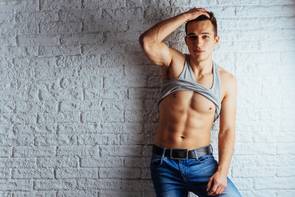 Portrait of a man with nude torso fitness standing in jeans and  - Foto, imagen
