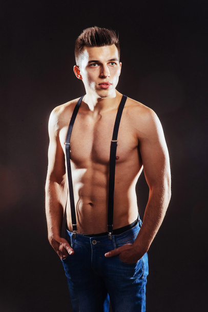Portrait of a man with nude torso fitness standing in jeans with - Photo, Image