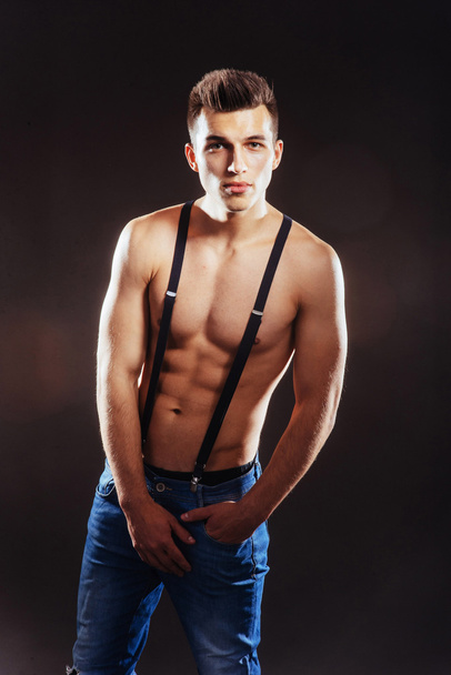 Portrait of a man with nude torso fitness standing in jeans with - Fotografie, Obrázek