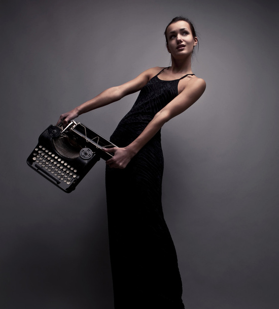 Elegant woman pose with ancient typewriter. - Foto, afbeelding
