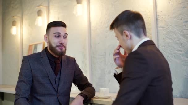 Two smiling business men have coffe break in cafe - Felvétel, videó