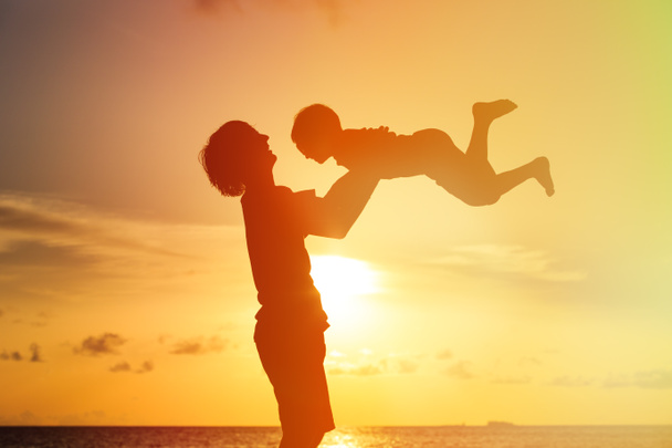 isä ja pieni poika siluetit pelata auringonlaskun aikaan
 - Valokuva, kuva