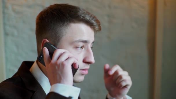 happy young businessman talking on cellphone in cafe - Záběry, video