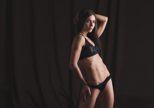 Fitness girl on dark background. - Fotó, kép