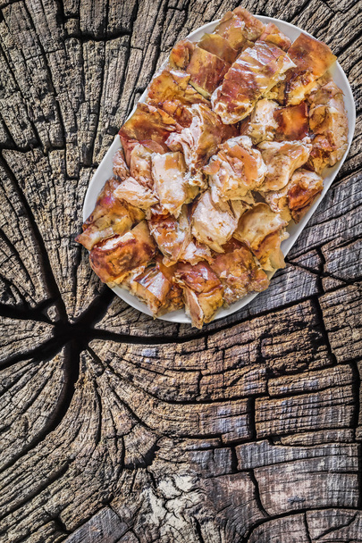 Tabak dolusu tükürük kavrulmuş domuz eti dilim eski kırık kütük yüzeyi - Fotoğraf, Görsel