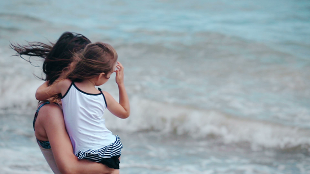 Moeder en dochter knuffel zoenen op het strand - Video