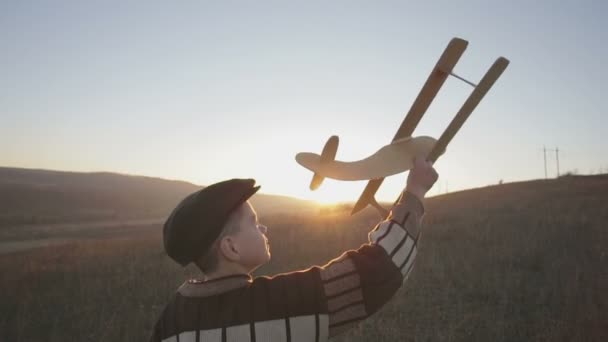Little boy with wooden plane - Кадры, видео