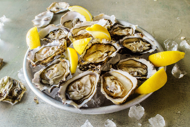 Opened Oysters with lemon - Foto, afbeelding