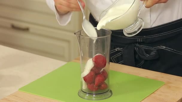 Szef kuchni jest mieszanie truskawki, jogurt i miód w misce do zrobić Smoothies - Materiał filmowy, wideo