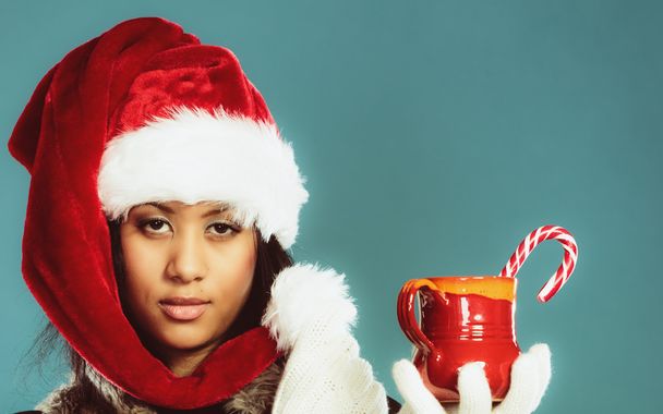 Winter girl santa helper hat holds red mug - Foto, Imagem