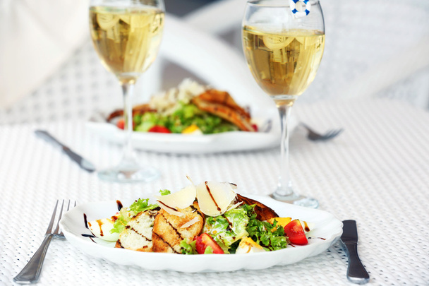 Tasty salad with wine on white served table - Photo, Image