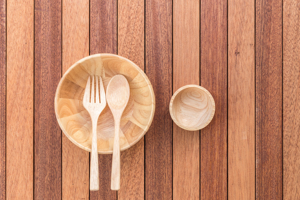 Empty bowl, fork and spoon on wooden table - Fotó, kép