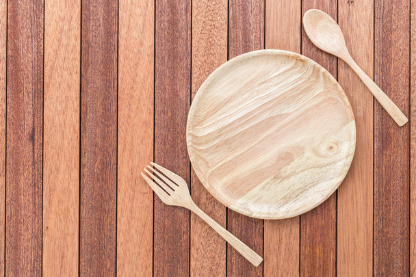 Empty wooden dish, fork and spoon on wooden table - Fotoğraf, Görsel