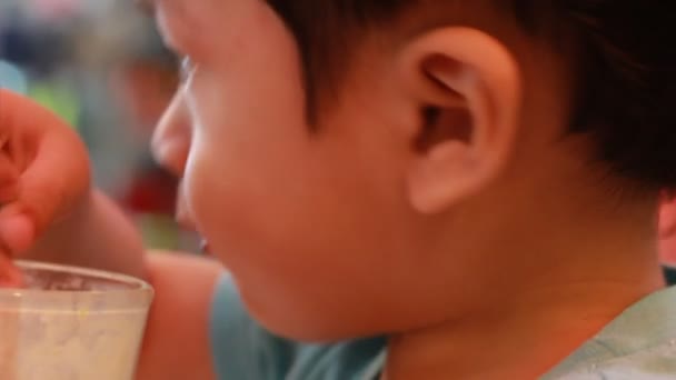 Kleine jongen schoot ijs in een tijdens de zomer, close-up - Video