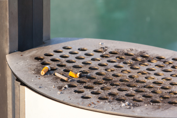 Füstölt cigaretta egy piszkos szabadban hamutartót - Fotó, kép