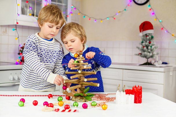 2 つは小さなクリスマス ツリーを飾る男の子を子供します。 - 写真・画像