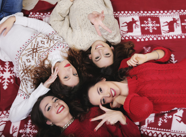 Sorridente Ragazza felice gruppo di amici a Capodanno maglione sdraiato sul pavimento Divertirsi insieme nel periodo delle vacanze invernali
 - Foto, immagini