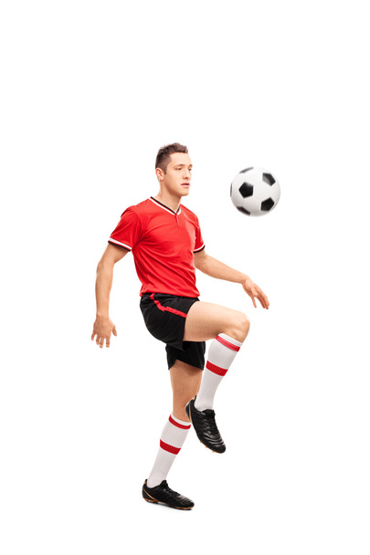 Young football player juggling a ball - Foto, afbeelding