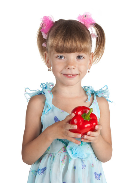A little sweet girl with a red pepper in her hand - Zdjęcie, obraz