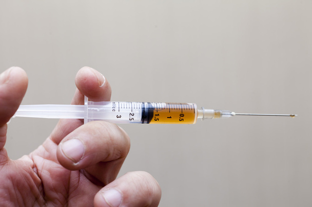 Syringe in a hand - Фото, зображення