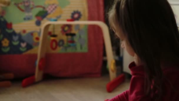 Cute little girl playing with toy blocks at home - Video