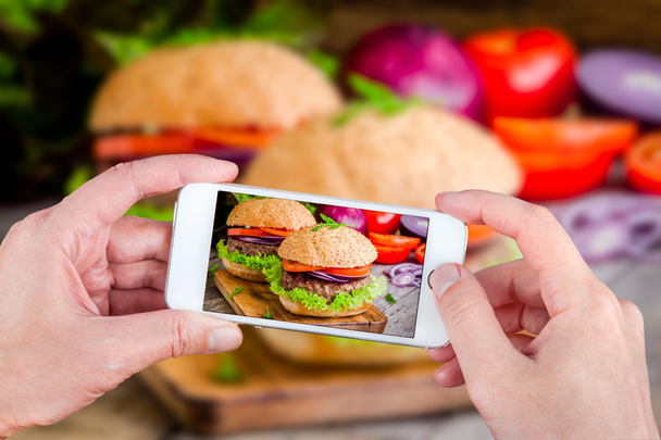 Mãos tirando hambúrgueres de fotos com smartphone
 - Foto, Imagem