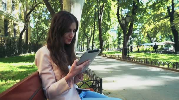 vrouwelijke student met behulp van een tablet in park - Video