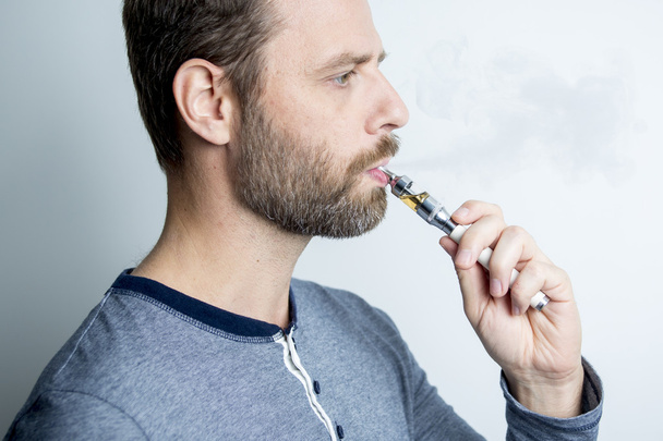 portrait of a young man smoking electric cigarette - Zdjęcie, obraz