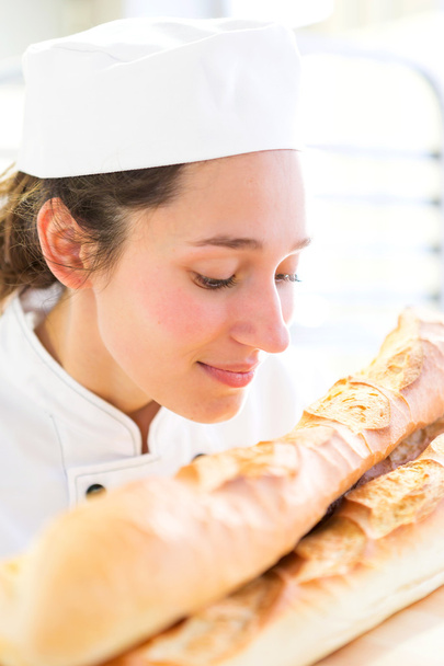 Young attarctive baker working at the bakery - Fotoğraf, Görsel