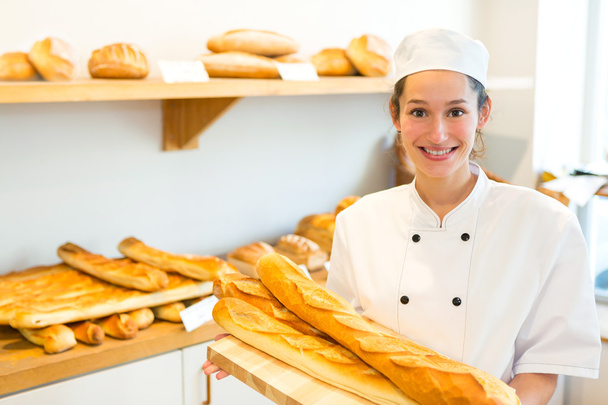 Young attarctive baker working at the bakery - Fotó, kép