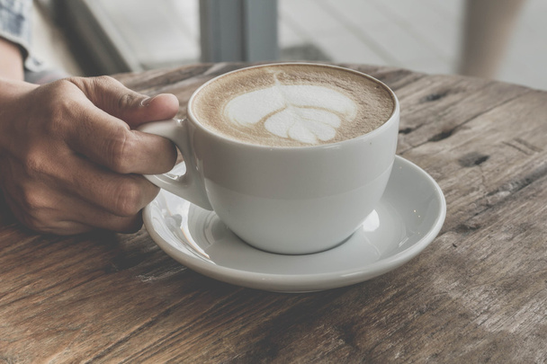 Bir fincan kahve latte sanat eski ahşap arka plan - Vintage filtre efekti üzerinde kapatın - Fotoğraf, Görsel