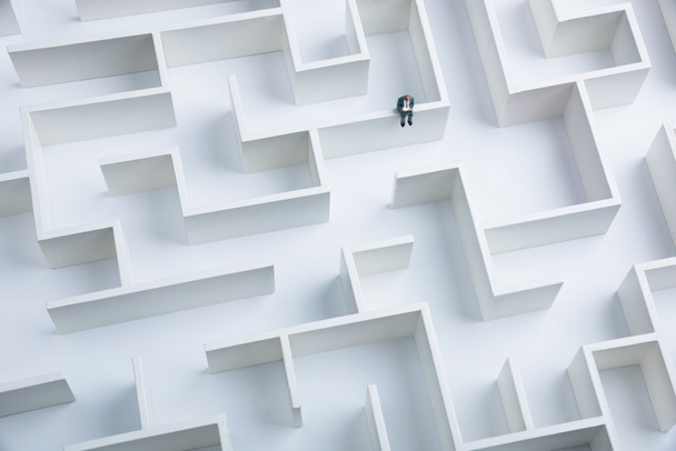 Empresário sentado em cima da parede do labirinto
 - Foto, Imagem
