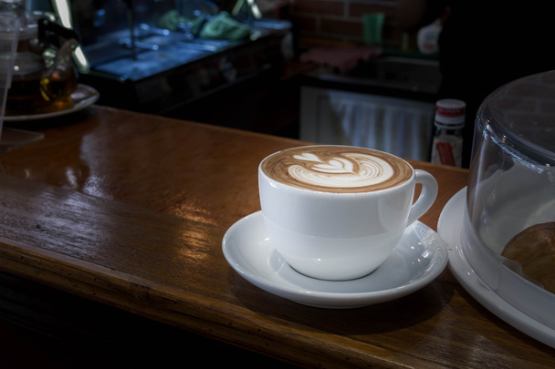 Close-up van witte kop koffie, latte op houten tafel - Foto, afbeelding