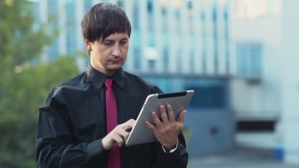 komea liikemies käyttäen tabletti kadulla hidastettuna
 - Materiaali, video