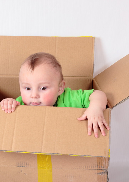 Kid climbs out of the box - Foto, imagen