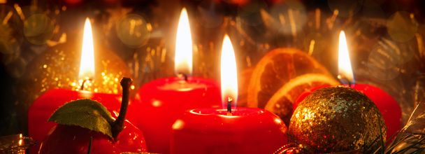 Quatre bougies rouges avec boule de Noël dans la lumière atmosphérique
. - Photo, image