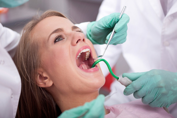 dentist is treating teeth of the female patient,close up. - Zdjęcie, obraz
