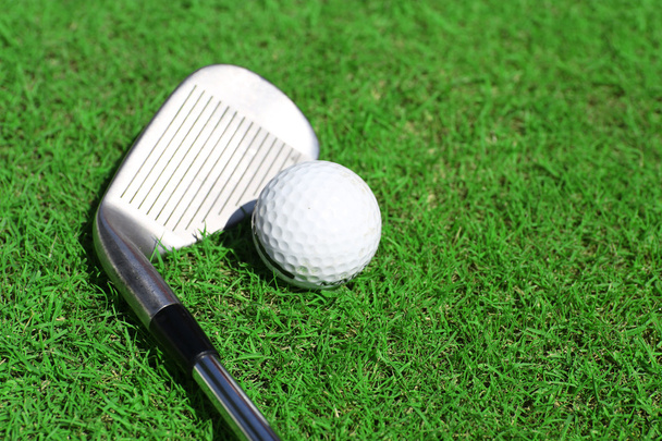 Golf club and ball on a green grass - Фото, зображення