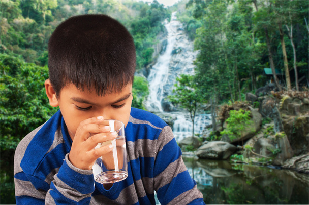 küçük sevimli çocuk içme suyu doğa arka plan üzerinde - Fotoğraf, Görsel