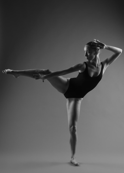 Modern ballet dancer posing on dark background - Fotó, kép